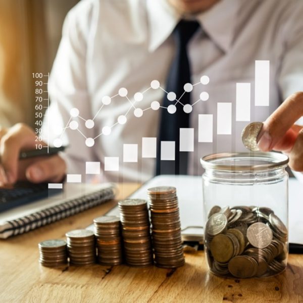 businessman holding coins putting in glass with using smartphone and calculator to calculate  concept saving money for finance accounting